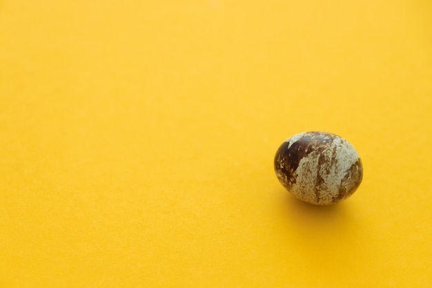 Small quail eggs on a yellow background healthy food