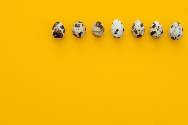 Small quail eggs on a yellow background healthy food