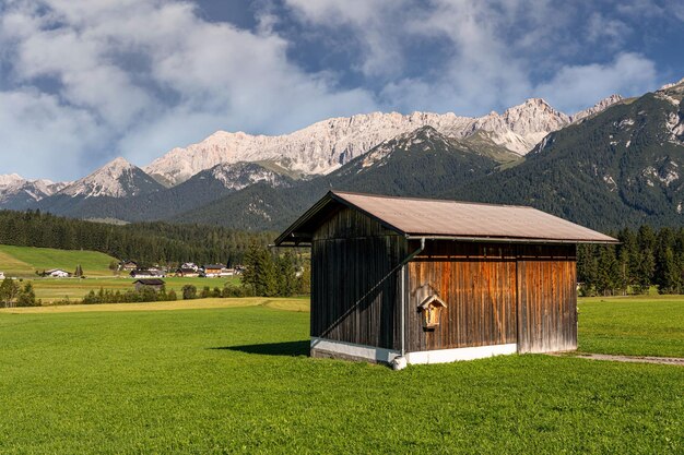 A small quaint house nestled in a stunningly vibrant green meadow in Leutasch Tyrol Austria