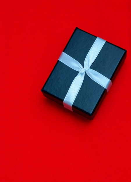 Small rectegular black gift box on a red background