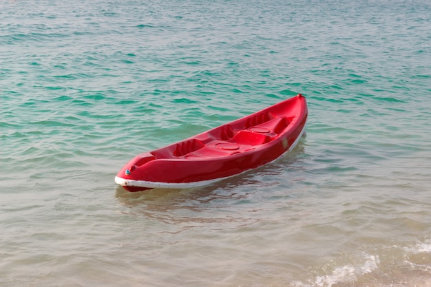 Piccola barca rossa sulla spiaggia.