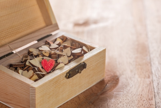 Photo small red heart in box on wooden table