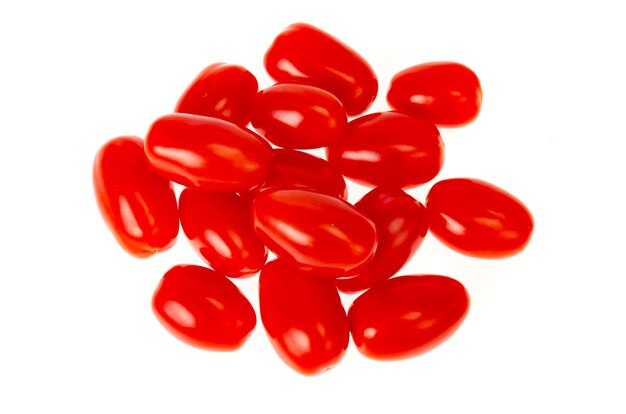 Small red oval cocktail cherry tomatoes on white background. Studio Photo