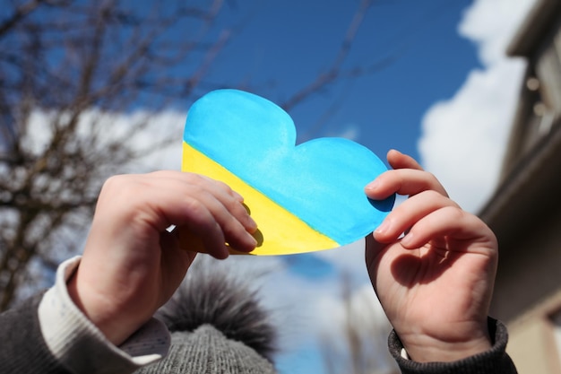 A small refugee boy from Ukraine with a drawing of the Ukrainian flag