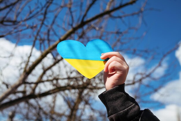 A small refugee boy from Ukraine with a drawing of the Ukrainian flag