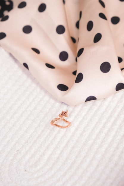 A small ring is on a bed.