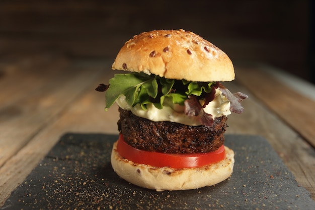 small rustic hamburger with tomato and white sauce