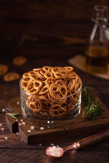 Small salted pretzels with salt oil and spices in a glass bowl, close-up