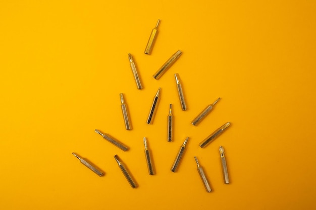 Small screwdriver bits on a yellow background