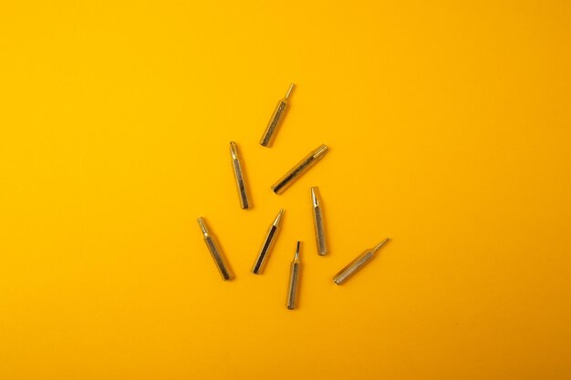 Small screwdriver bits on a yellow background