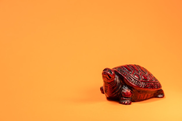 Small sculpture of a terra cotta colored African tortoise walkinging space