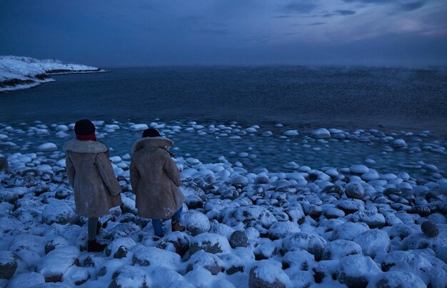 Небольшие морские волны разбиваются о камни берега в яркий солнечный день и белая пена волн, тающих ледников, как воздействие загрязнения воздуха на окружающую среду