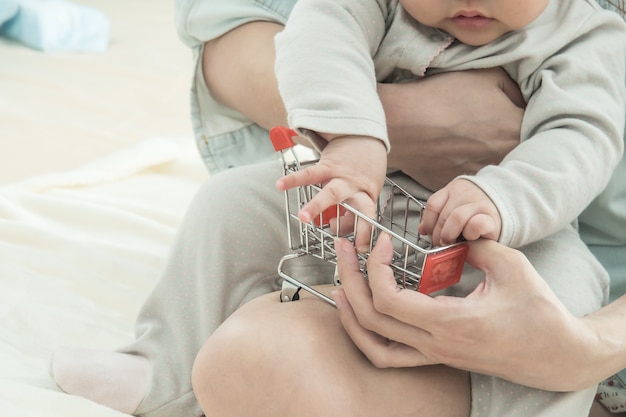 小さなショッピングカートとぼやけた赤ちゃんとお母さん