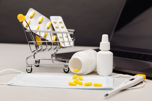 약이 든 작은 쇼핑 카트. 의약품 개념의 온라인 구매.
