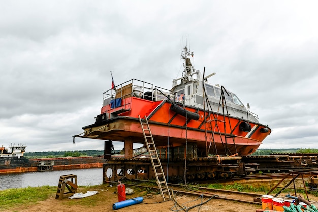 Small sized vessel ashore on ship repairing yard