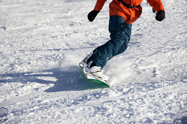 Small snowboarder on blue sky backdrop.