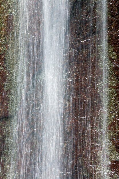 小さな春の山の滝と背後の岩