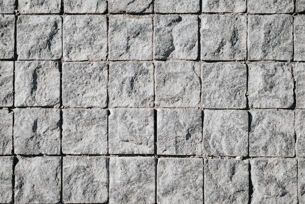 Small stone decorative uneven rough tiles pedestrian road texture closeup