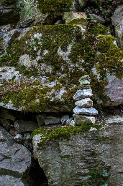 苔で覆われた石を背景にした小さな石のピラミッド