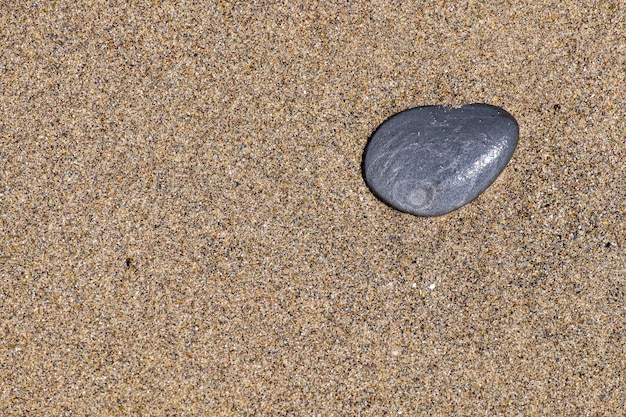 A small stone rounded by the erosion of sand and waves