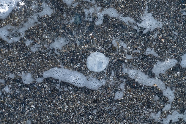 A small stone rounded by the erosion of sand and waves