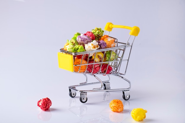 Small store trolley with color popcorn on white surface