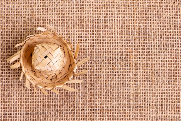 ジュート生地のテーブルのフェスタジュニーナの飾りに使用される小さな麦わら帽子。