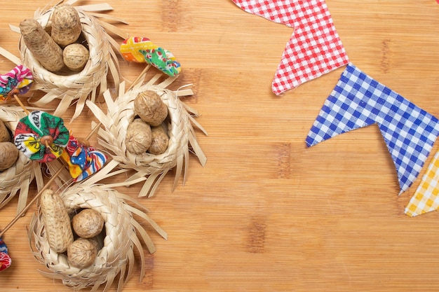 Small straw hats filled with peanuts with Brazilian festa junina decorations