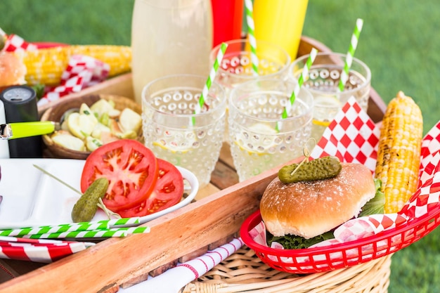 Небольшой летний пикник с лимонадом и гамбургерами в парке.