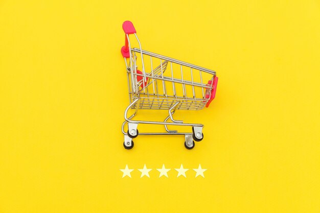 Small supermarket grocery push cart for shopping toy with wheels and 5 stars rating isolated on yellow background.