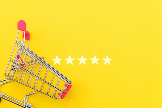 Small supermarket grocery pushcart and stars rating isolated on yellow background