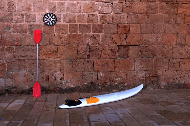 Small surf board or surfboard at the city standig near the stone wall. Summer vacation concept.