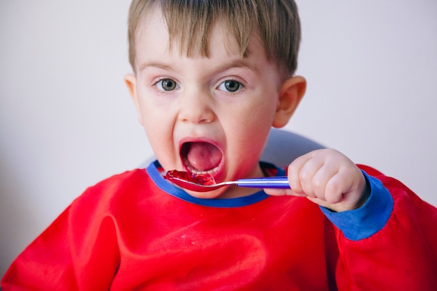 自分で昼食をとっている小さな幼児。家族と健康的な食事のライフスタイル。