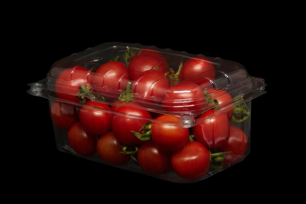 Small tomatoes in plastic packaging on a black background