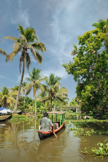 Photo small tourist boat on beautiful backwaters landscape with palm trees