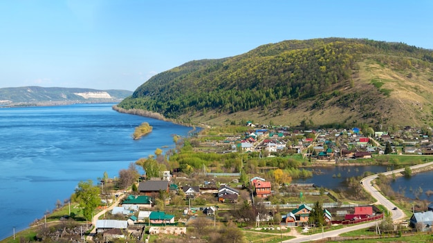 Городок на фоне реки и гор.