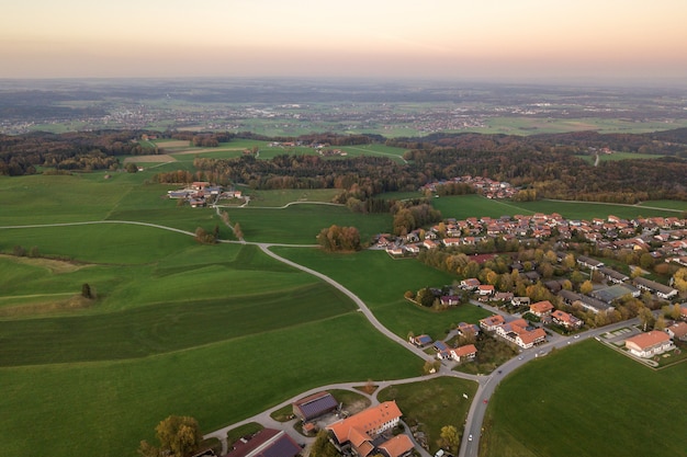 small town with red tiled roofs among green farm fields