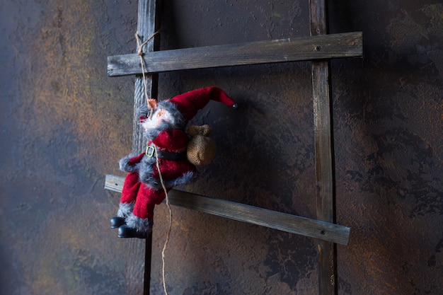 Small toy in the form of Santa Claus on a wooden ladder