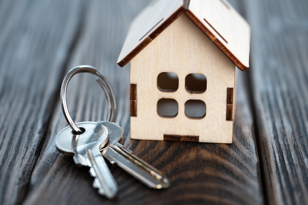 Small toy house with keys on the brown wooden boards