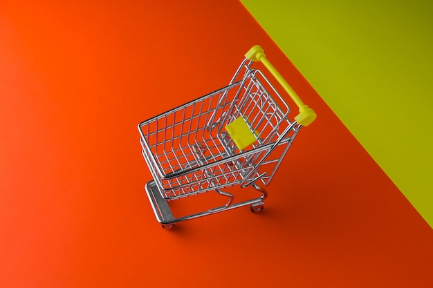 Small trolley on a orange and yellow foreground table. Blackfriday and cybermonday concept