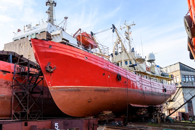 Small vessel ashore on ship repairing yard