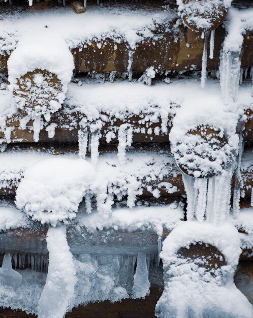 A small wall of small logs background under snow at winter