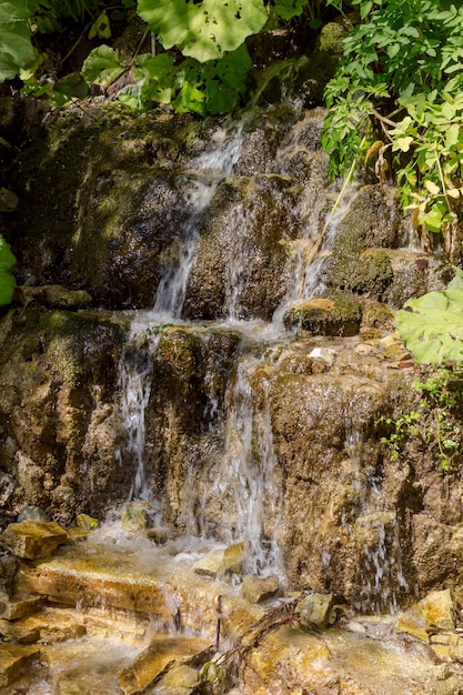 A small waterfall flowing from the mountain in a sunny summer day region Tzoumerka Greece mountains Pindos