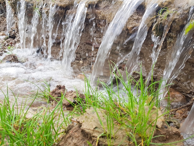 Небольшой водопад. Текущая вода размывает почву.