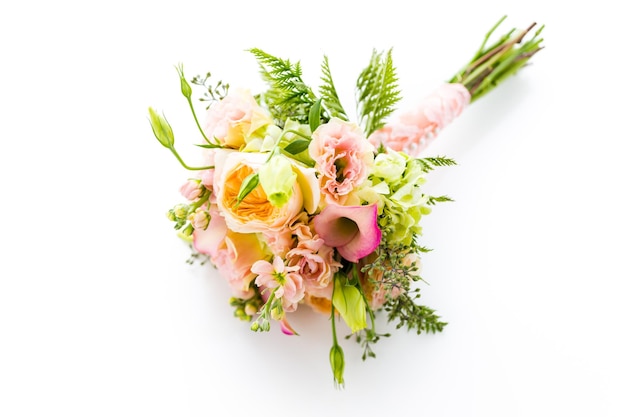 Piccolo bouquet da sposa con rose su sfondo bianco.