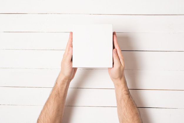 Small white cardboard boxes in male hands