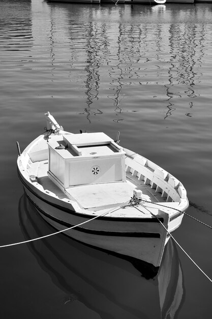 Small white fishing boat. Black and white photography. Heraklion, Greece