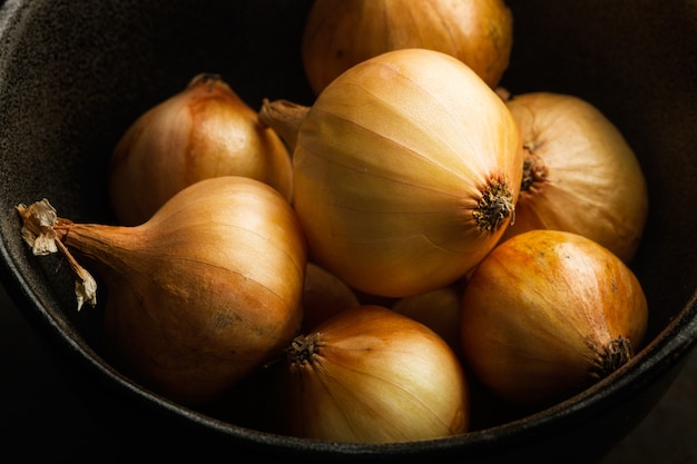 Foto piccole cipolle bianche francesi in una ciotola scura