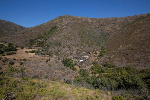 a small white house is in the middle of a mountain