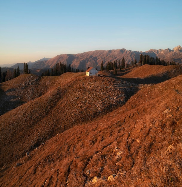 Small white house in the mountains at sunset during the golden autumn on the Chocolate Hills